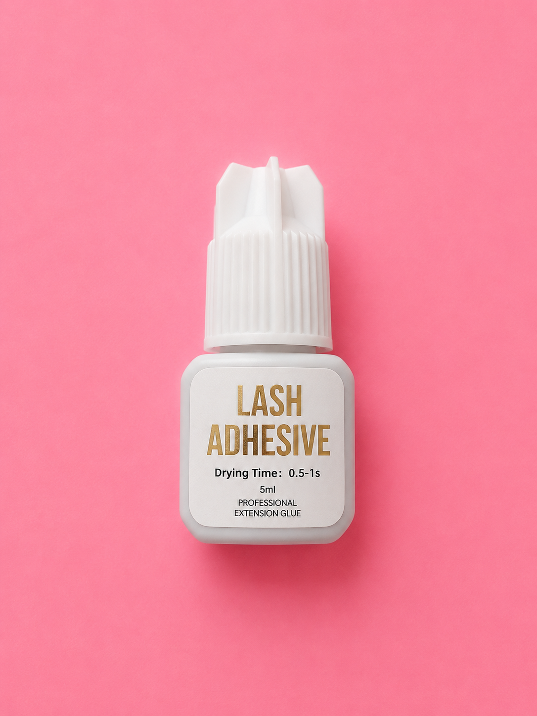 A 5ml bottle of Lash Adhesive with a white cap and a white label featuring gold lettering, centered on a solid pink background.0-5 sec Ultra Fast Black Lash Extension Adhesive Glue Bratty Beauty XO