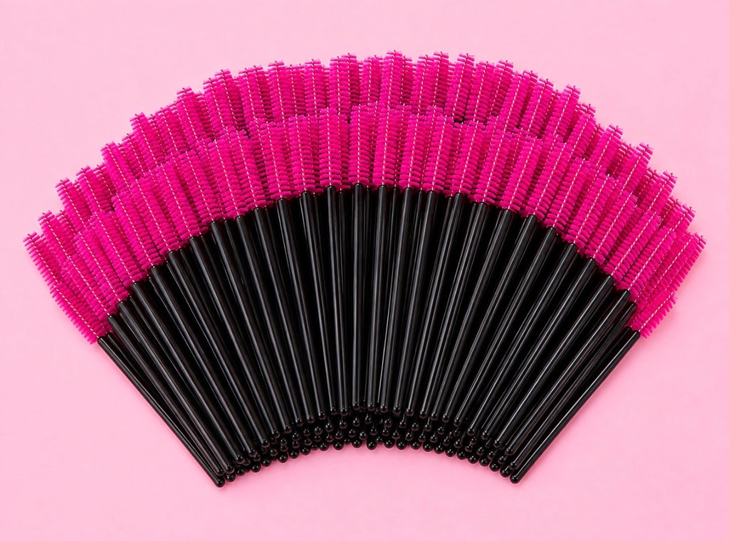 A fan arrangement of black and hot pink makeup spoolie brushes on a solid pink background.100 or 300 pcs | Disposable Lash Spoolies for Eyelash Extensions Bratty Beauty XO