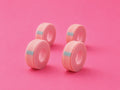 Four rolls of light pink athletic lash tape arranged on a solid pink background.4 Rolls Pretty Pink Soft Lash Tape For Eyelash Extensions Bratty Beauty XO
