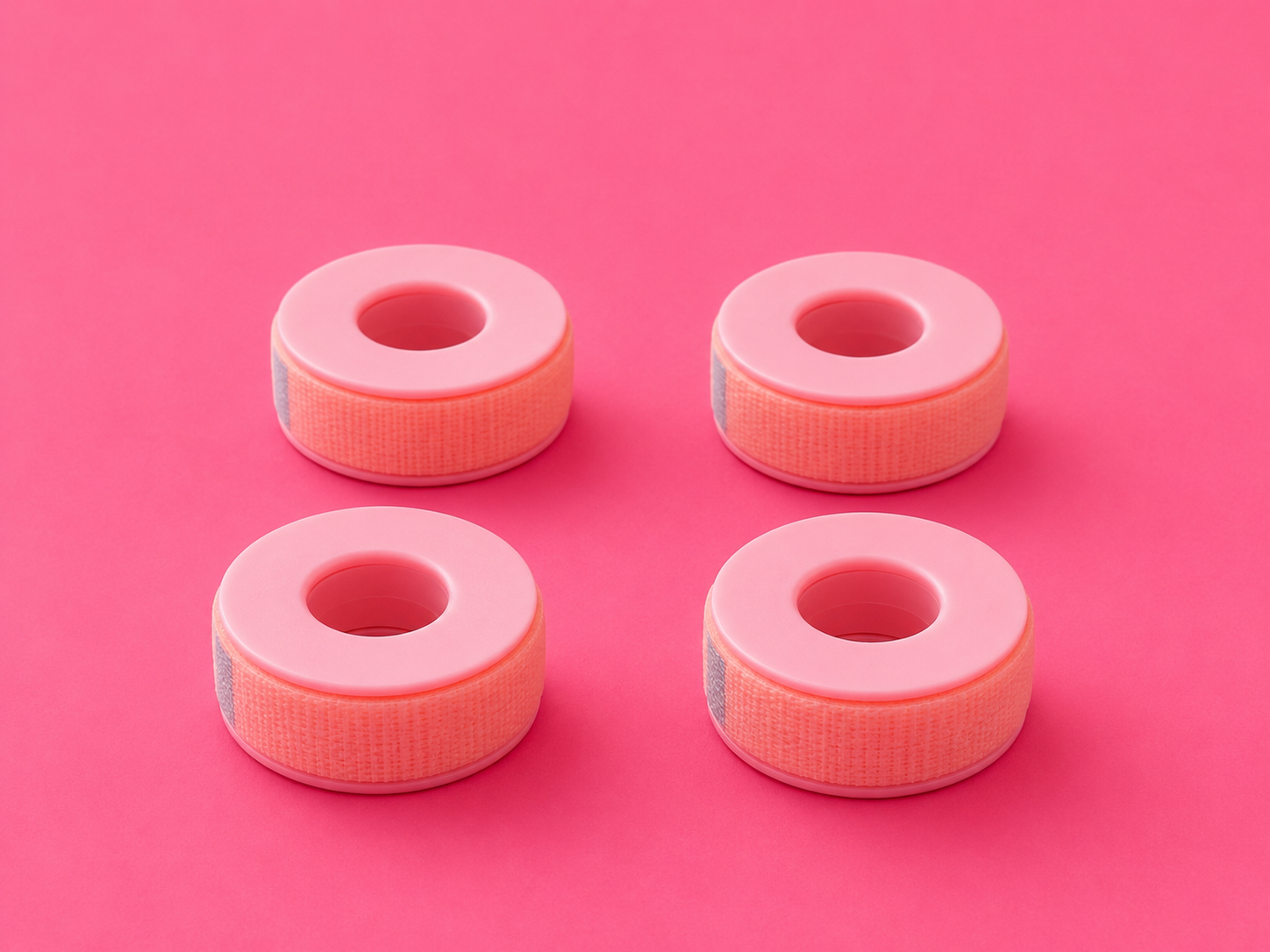 Four pink circular foam rings arranged in a 2x2 grid on a solid pink background.4 Rolls Pretty Pink Soft Lash Tape For Eyelash Extensions. Lash Supplies Bratty Beauty XO