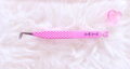 Pink diamond-textured tweezers with silver metal tips and bratty beauty printed on the handle, resting on a white faux fur surface next to a small pink heart-shaped object.Big Boss Fanning Tweezer, bratty beauty xo volume lash tweezer