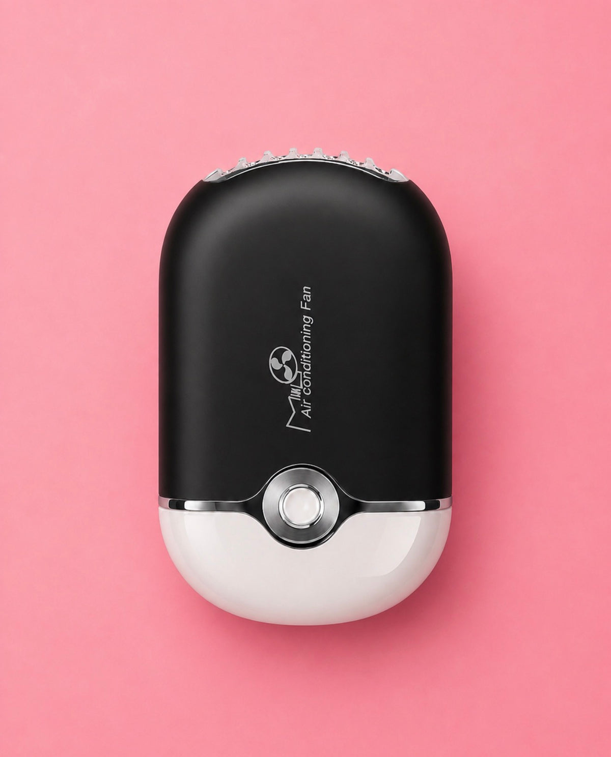 A compact personal care device with a matte black upper half and a glossy white lower half, centered on a solid pink background. The device features a silver metallic button at the center.Pink or Black Portable Mini Lash Fan for Eyelash Extensions Bratty Beauty XO