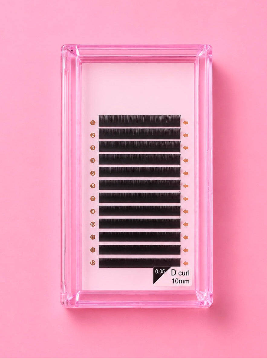 A pack of black D-curl eyelash extensions in a clear pink plastic tray, set against a solid pink background.Bratty Beauty XO Matte Black 0.05 D Curl 10mm Lash Extension Tray