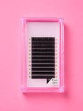 A pack of black false eyelash clusters in a clear pink plastic tray, displayed on a solid pink background. The label on the bottom right reads 0.05 12mm Bratty Beauty XO Matte Black 0.05 D Curl 12mm Lash Extension Tray