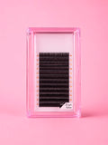 A pack of black false eyelashes with a D curl and 13 mm length, presented in a clear pink plastic case on a solid pink background.Bratty Beauty XO Matte Black 0.05 D Curl 13mm Lash Extension Tray 
