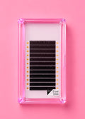 A pack of black false eyelash clusters in a clear pink plastic case, displayed on a solid pink background. Bratty Beauty XO Matte Black 0.07 D Curl 12mm Lash Extension Tray