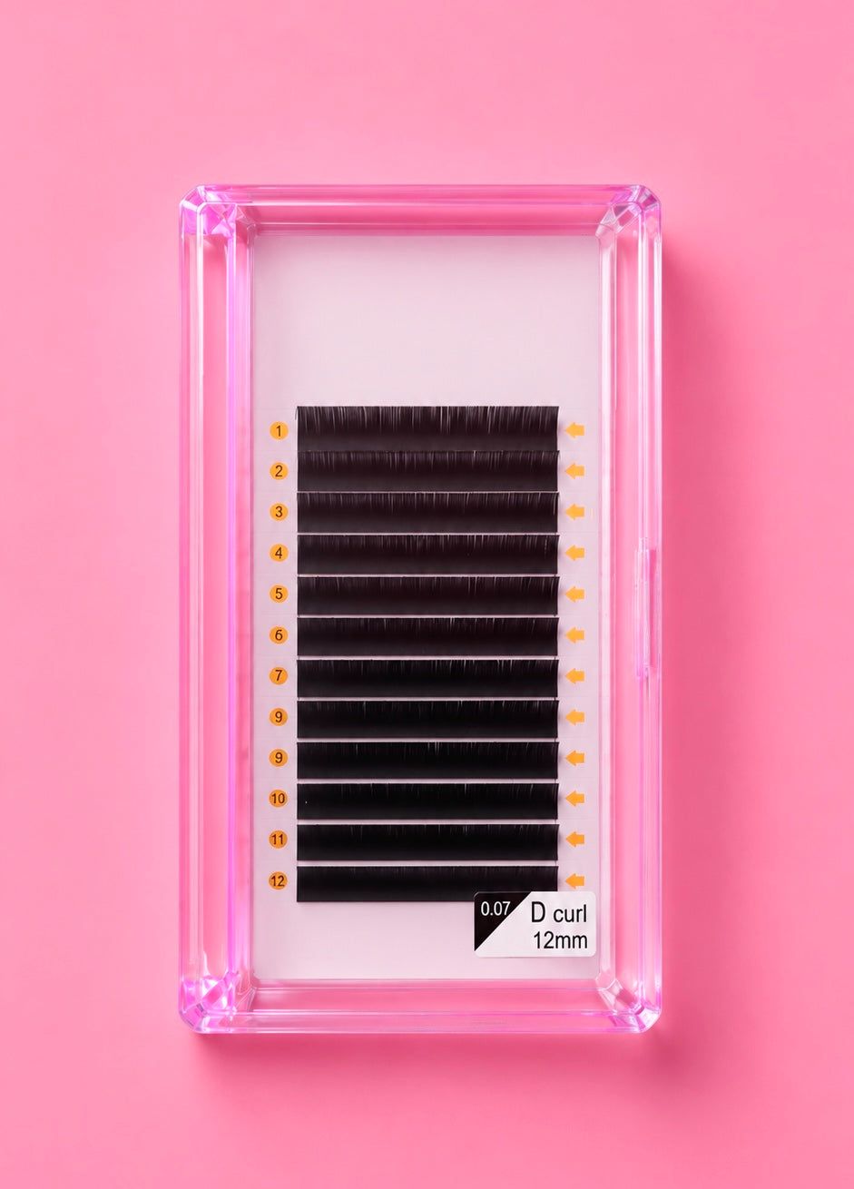 A pack of black false eyelash clusters in a clear pink plastic case, displayed on a solid pink background. Bratty Beauty XO Matte Black 0.07 D Curl 12mm Lash Extension Tray
