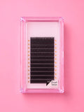 A pack of black false eyelash clusters in a clear pink plastic case, displayed on a solid pink background. Bratty Beauty XO Matte Black 0.07 D Curl 14mm Lash Extension Tray