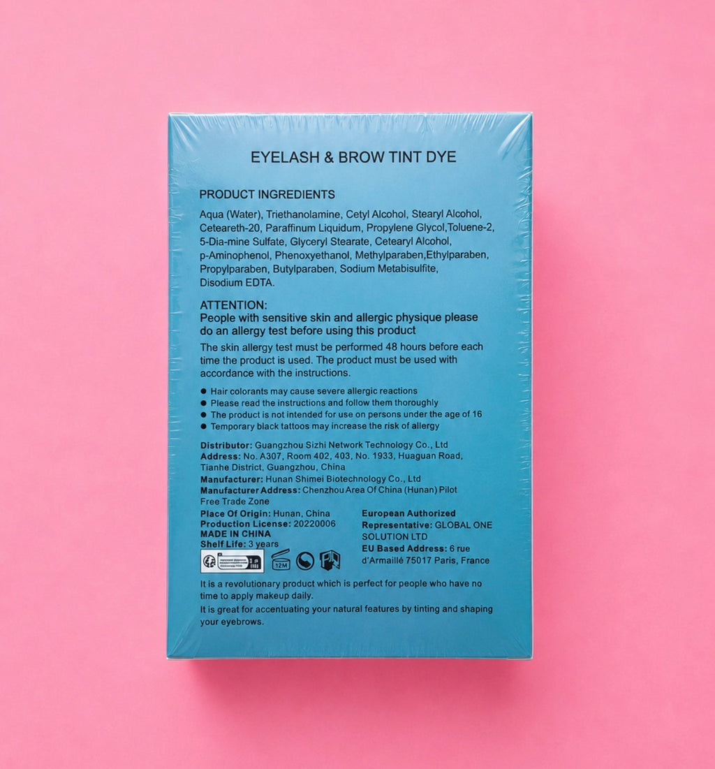 The back of a light blue rectangular box for an eyelash and brow tint, photographed against a pink background. The box contains product ingredients, usage instructions, and regulatory text in black print.Professional Eyelash & Brow Tint Dye Kit Bratty Beauty XO