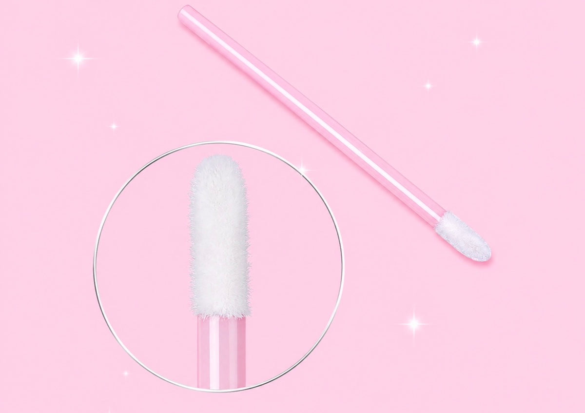 A pink makeup sponge applicator with a white fluffy tip, shown on a pink background with a circular zoom-in detail of the sponge headPink or Black Disposable Lip Brushes/ Lip Wands | 500 or 700 pcs