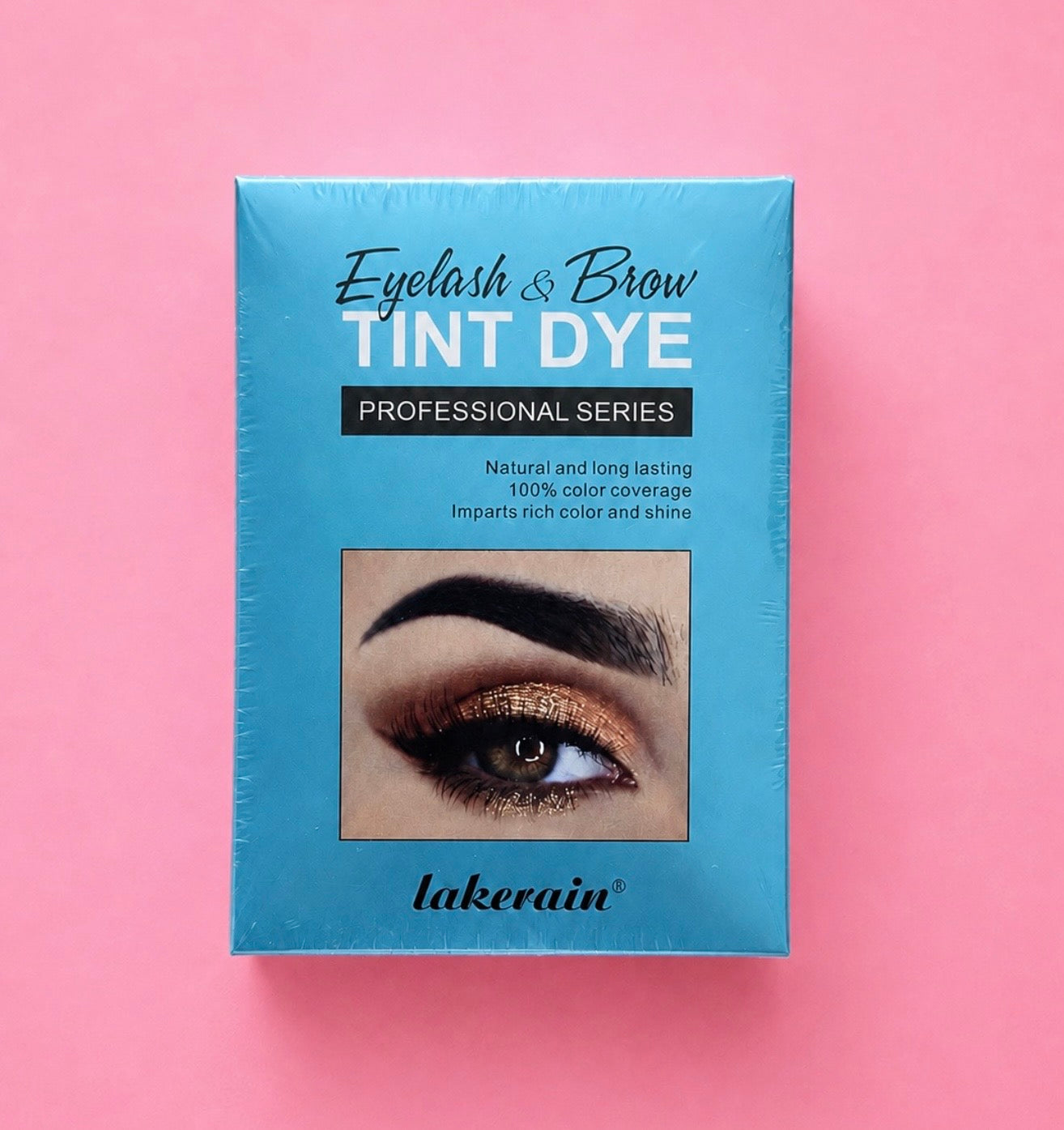 A rectangular box of Lakerain Eyelash & Brow Tint Dye Professional Series, featuring a bright blue packaging with a sample eye makeup photo, set against a solid pink background.Professional Eyelash & Brow Tint Dye Kit Bratty Beauty XO