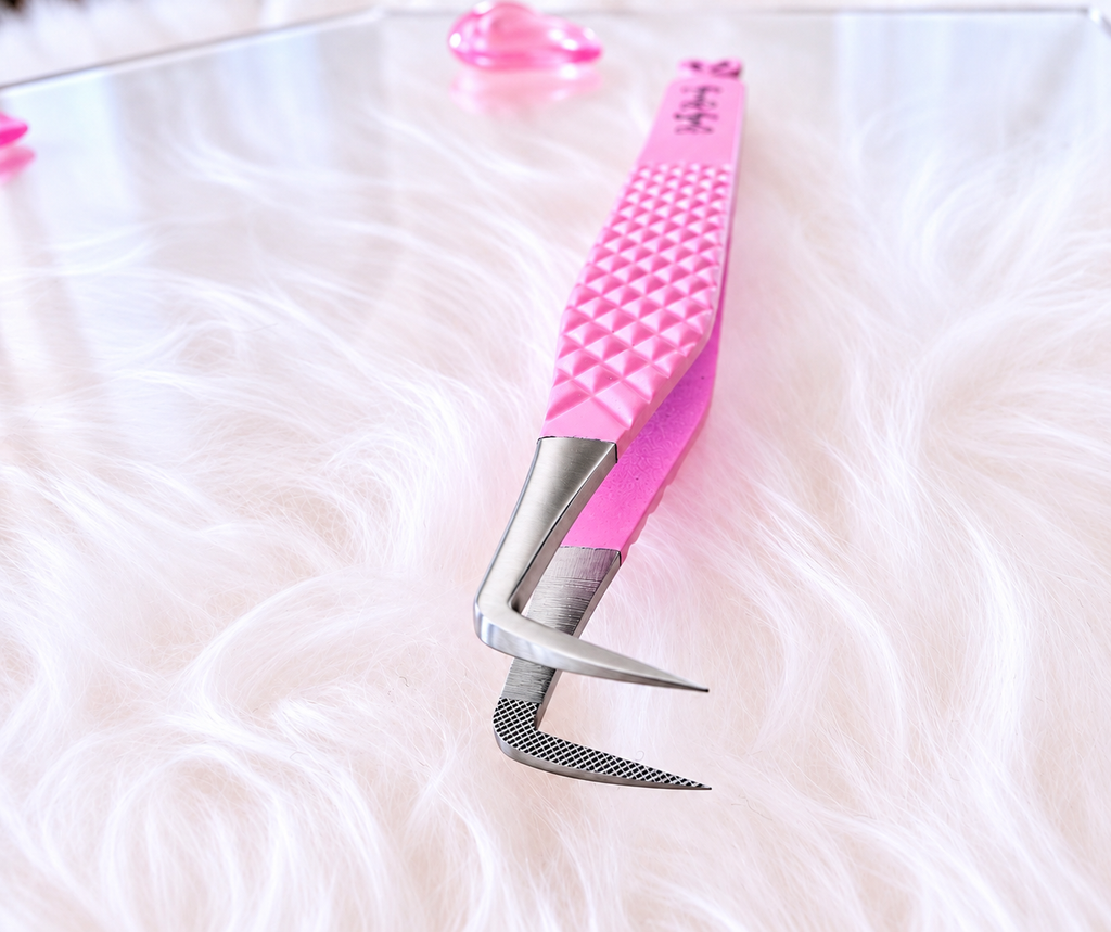 A pair of pink and silver curved eyelash tweezers with a textured pink handle, resting on a white faux fur surface.Big Boss Fanning Tweezer, bratty beauty xo volume lash tweezer