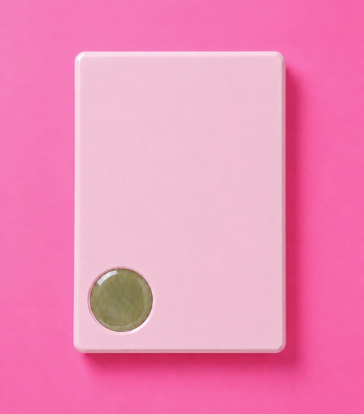 A minimalist light pink rectangular device with rounded corners and a small oval green window near the bottom left top place the lash adhesive glue, shown on a solid pink background.Rosie Pink Acrylic Lash Tile Bratty Beauty XO