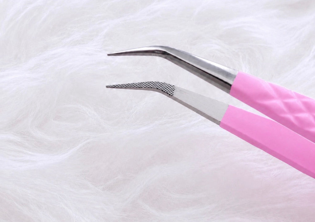 Pink and silver metal tweezers with curved tips, shown against a soft white faux fur background.Boss Isolation Tweezer bratty beauty xo volume lash tweezer